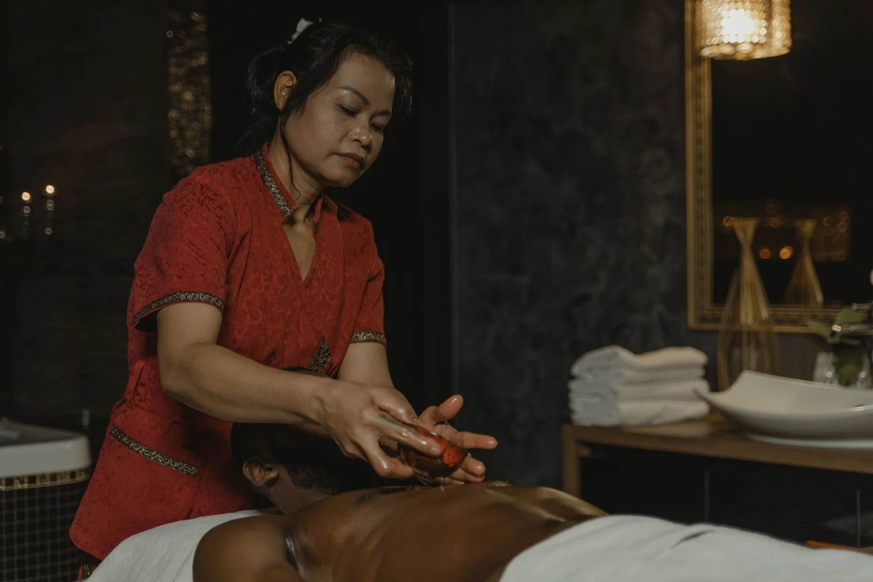 Professional massage specialist preparing a relaxing spa session